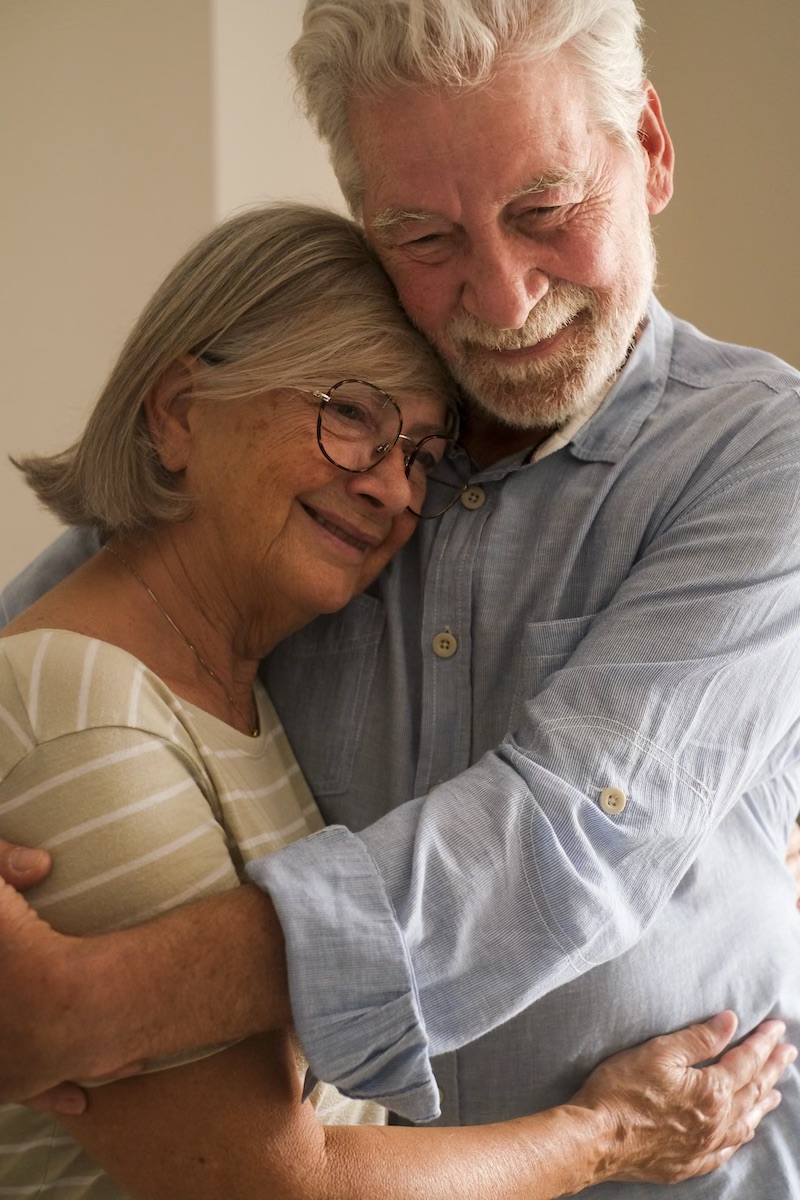 Elderly care mature couple hugging and dreaming together at home. One senior man and woman bonding each other smiling. Happy love and relationship elderly lifestyle people indoor leisure activity